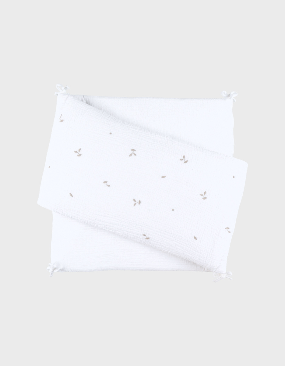 Breathable white embroidered cot bumper in muslin
