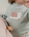 Baby pyjama van groene velours met slakkenborduursel
