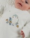 Baby pyjama van witte velours met vogelborduursel
